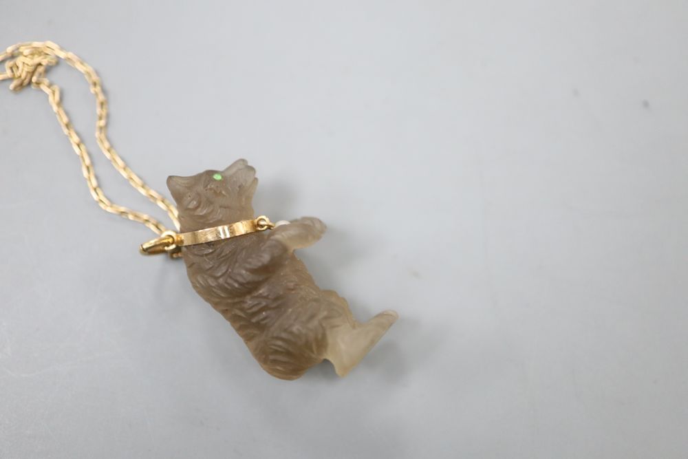 A carved quartz or glass bear pendant, on a yellow metal chain, chain 34cm.